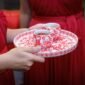 Sepasang pengantin Tionghoa sedang melakukan upacara teh, sebuah ritual penting yang melambangkan penghormatan kepada orang tua dan kerabat yang lebih tua, sekaligus menerima restu serta nasihat bijak untuk perjalanan rumah tangga mereka.