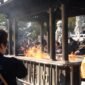 Beberapa orang membakar uang kertas sembahyang dan replika barang-barang di depan makam saat perayaan Qingming, sebuah tradisi kuno yang masih lestari hingga kini sebagai wujud penghormatan kepada leluhur. Aroma dupa dan asap pembakaran ritual ini memenuhi udara, menciptakan suasana khidmat dan reflektif di pemakaman.