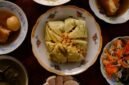 Meja makan dipenuhi aneka hidangan khas Peranakan yang memukau mata dengan warna-warni cerah dan aroma rempah menggoda, sebuah perayaan kekayaan kuliner yang melambangkan harmonisasi budaya. Setiap piring menceritakan warisan berharga dari generasi ke generasi, siap memanjakan lidah dan membawa kita pada perjalanan rasa yang tak terlupakan.