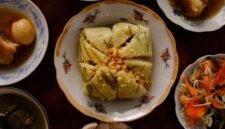 Meja makan dipenuhi aneka hidangan khas Peranakan yang memukau mata dengan warna-warni cerah dan aroma rempah menggoda, sebuah perayaan kekayaan kuliner yang melambangkan harmonisasi budaya. Setiap piring menceritakan warisan berharga dari generasi ke generasi, siap memanjakan lidah dan membawa kita pada perjalanan rasa yang tak terlupakan.