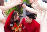 Mempelai wanita mengenakan gaun pernikahan tradisional Tionghoa berwarna merah cerah dengan bordir naga dan burung phoenix, melambangkan keberuntungan serta kebahagiaan. Pakaian ini mencerminkan kekayaan budaya yang diwariskan turun-temurun.