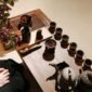 Sebuah poci teh yang sedang disajikan dengan cangkir-cangkir kecil di sekitarnya, merefleksikan kehangatan dan ritual sosial dalam tradisi minum teh yang berbeda-beda di seluruh dunia. Gambar ini menunjukkan keragaman cara menikmati teh, dari yang sederhana hingga upacara yang rumit, sebagai bagian tak terpisahkan dari kehidupan manusia.