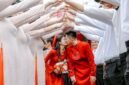 Pasangan pengantin Tionghoa tengah melakukan upacara minum teh, sebuah ritual sakral yang melambangkan penghormatan kepada orang tua dan tetua keluarga, serta penerimaan restu untuk kehidupan pernikahan mereka. Gaun merah yang dikenakan mempelai wanita menjadi simbol keberuntungan dan kebahagiaan abadi dalam tradisi pernikahan Tionghoa.