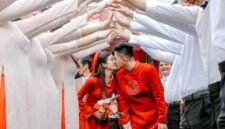 Pasangan pengantin Tionghoa tengah melakukan upacara minum teh, sebuah ritual sakral yang melambangkan penghormatan kepada orang tua dan tetua keluarga, serta penerimaan restu untuk kehidupan pernikahan mereka. Gaun merah yang dikenakan mempelai wanita menjadi simbol keberuntungan dan kebahagiaan abadi dalam tradisi pernikahan Tionghoa.