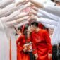 Pasangan pengantin Tionghoa tengah melakukan upacara minum teh, sebuah ritual sakral yang melambangkan penghormatan kepada orang tua dan tetua keluarga, serta penerimaan restu untuk kehidupan pernikahan mereka. Gaun merah yang dikenakan mempelai wanita menjadi simbol keberuntungan dan kebahagiaan abadi dalam tradisi pernikahan Tionghoa.