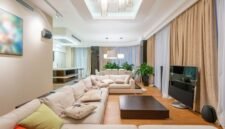 Sebuah ruang keluarga modern yang ditata dengan prinsip feng shui, menampilkan keseimbangan warna, tekstur, dan penempatan furnitur untuk menciptakan suasana harmonis serta aliran energi positif yang menyejukkan. Penempatan tanaman hidup dan pencahayaan alami mendukung kualitas chi yang optimal di dalam ruangan.